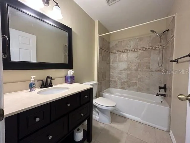 a bathroom with a bathtub shower sink vanity mirror and toilet