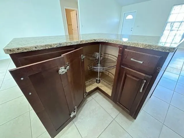 a kitchen with a granite countertop sink and cabinets