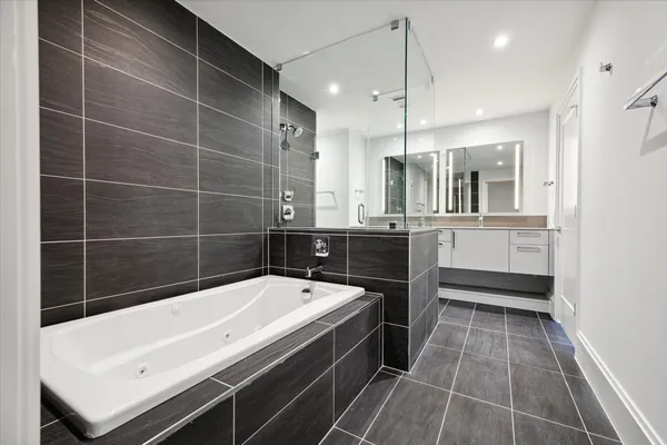 a bathroom with a tub a sink and a shower