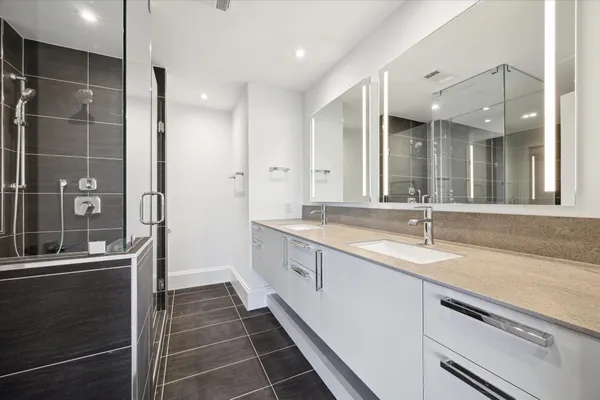 a large bathroom with a granite countertop sink a mirror and a shower
