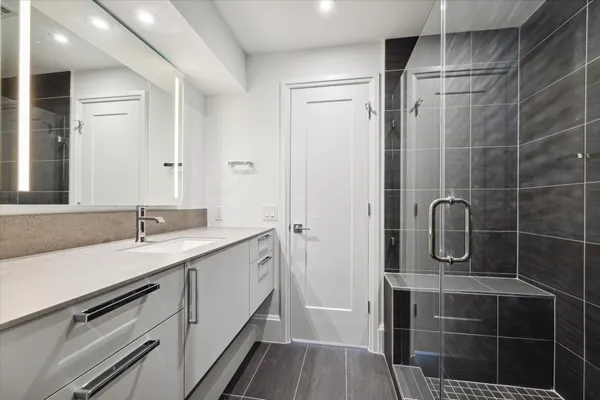 a bathroom with a granite countertop sink a toilet and shower