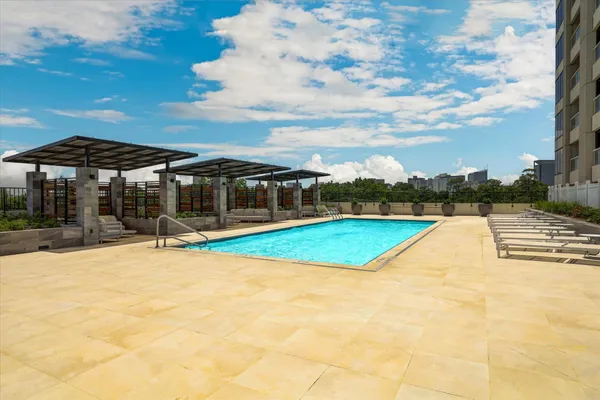 a view of swimming pool with lawn chairs under an umbrella
