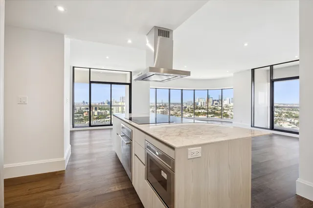 a kitchen with stainless steel appliances granite countertop a sink and wooden floor