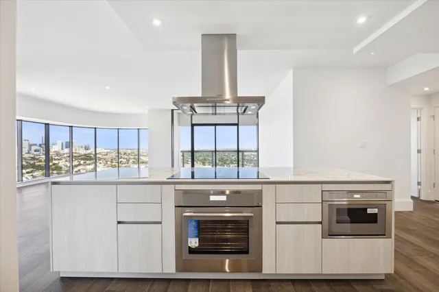 a kitchen with stainless steel appliances a stove and white cabinets