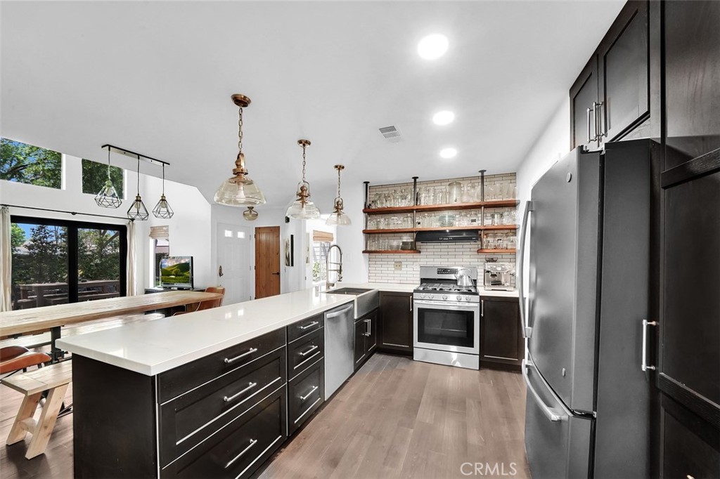 645 Springbrook North, Unit 21 Irvine, CA 92614 - Photo 1 of 1 a kitchen with stainless steel appliances a sink stove and refrigerator