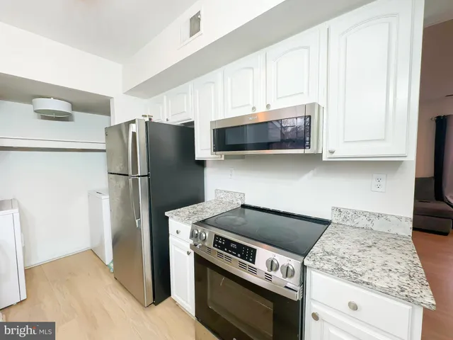 a kitchen with stainless steel appliances granite countertop a refrigerator stove and microwave