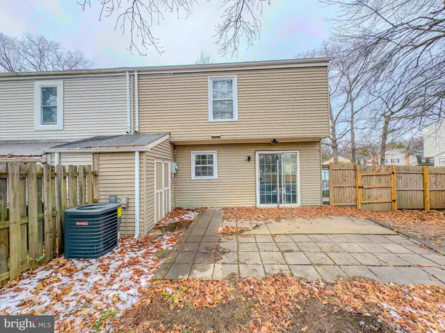 a view of a house with a large window and wooden fence