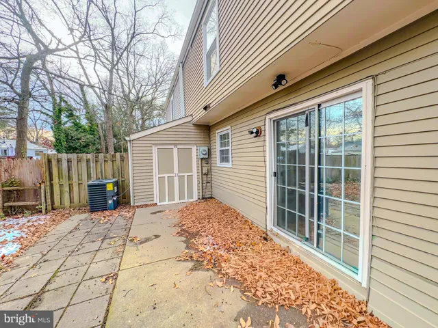 a backyard of a house with large trees and outdoor seating