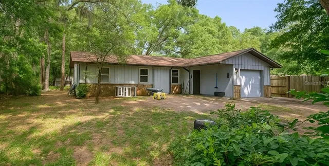 a view of a house with backyard and trees