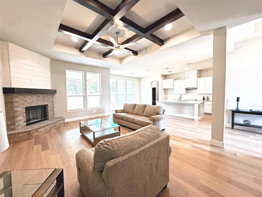 1005 Ronnie Court Springtown, TX 76082 - Photo 8 of 27 Open-concept living area featuring wood-finish flooring, a tray ceiling with exposed wood beams, and recessed lighting