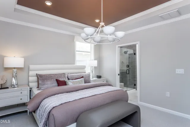 a bedroom with a large bed and a chandelier