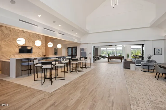 a living room with furniture a large window and stainless steel appliances