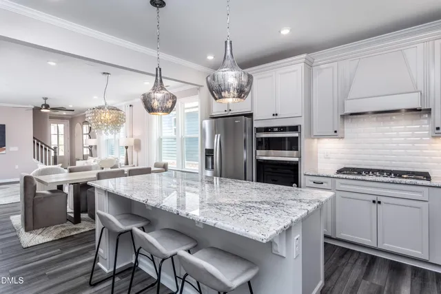 a kitchen with center island wooden floor center island and stainless steel appliances