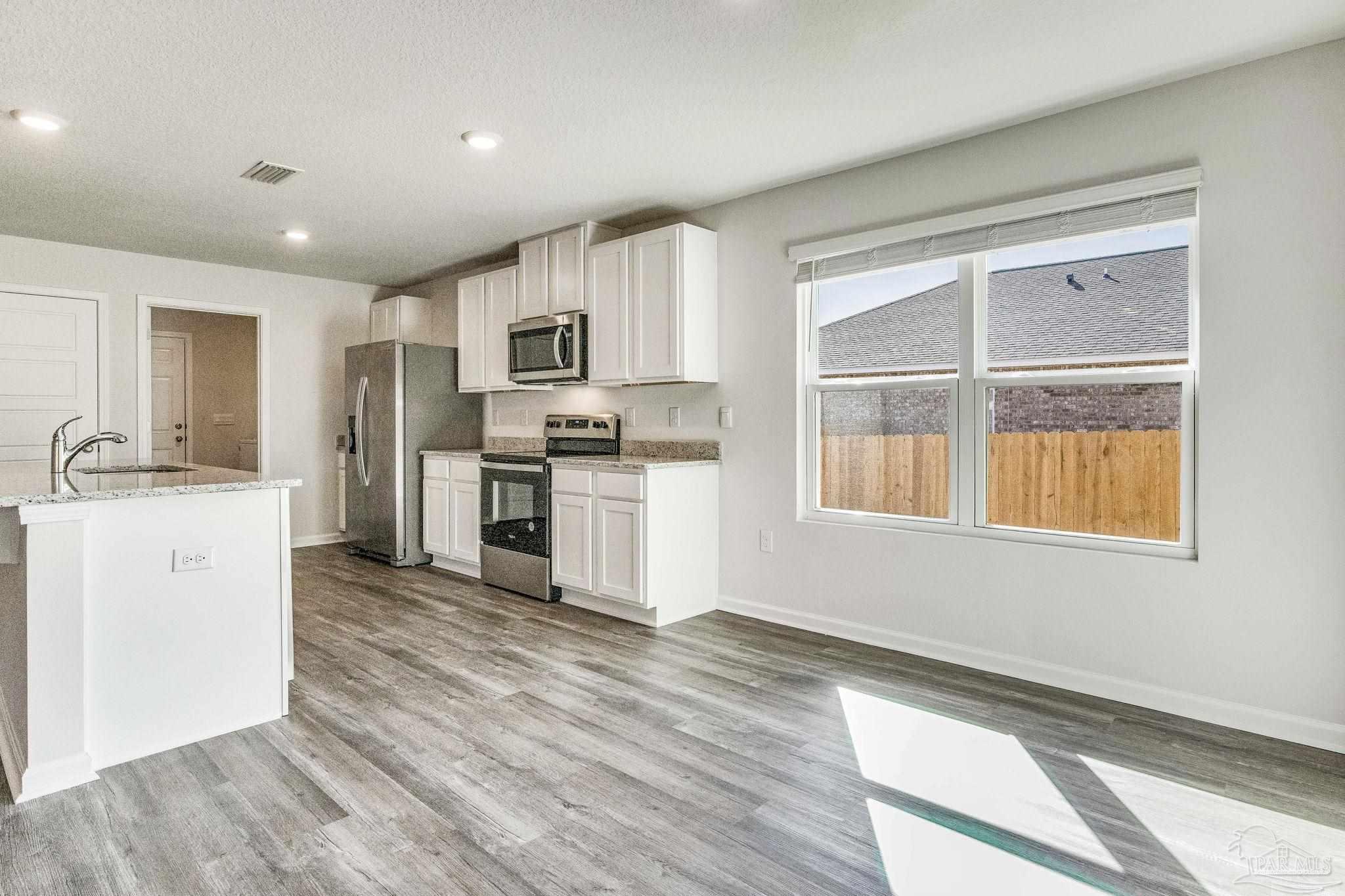 9823 MilleeLoop Loop Pensacola, FL 32526 - Photo 9 of 50 a kitchen with granite countertop a stove a sink and a refrigerator