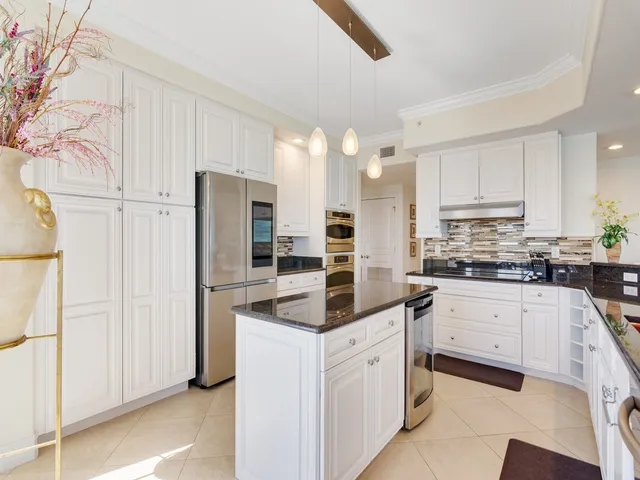 a living room with furniture kitchen and a large window