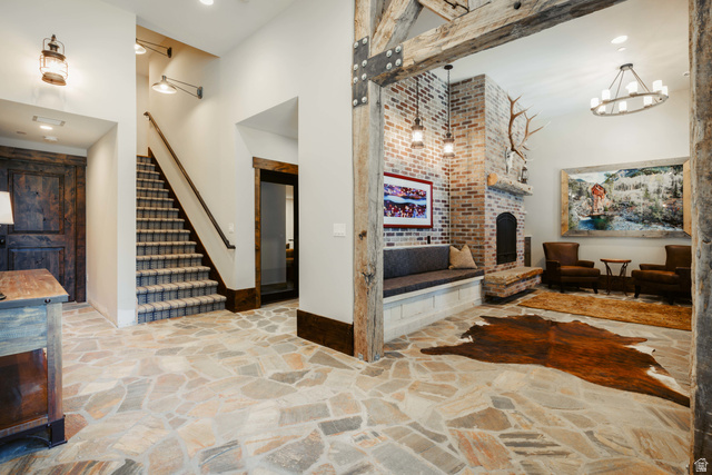 1667 West Tollgate Cyn Road Coalville, UT 84017 - Photo 44 of 61 Expansive room featuring irregular flagstone flooring, a brick fireplace with stone hearth, exposed wood beams, and a built-in bench