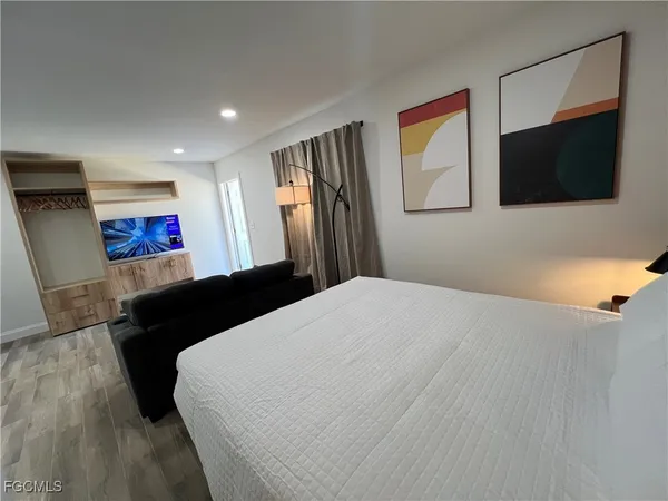 a bedroom with a bed and a flat screen tv