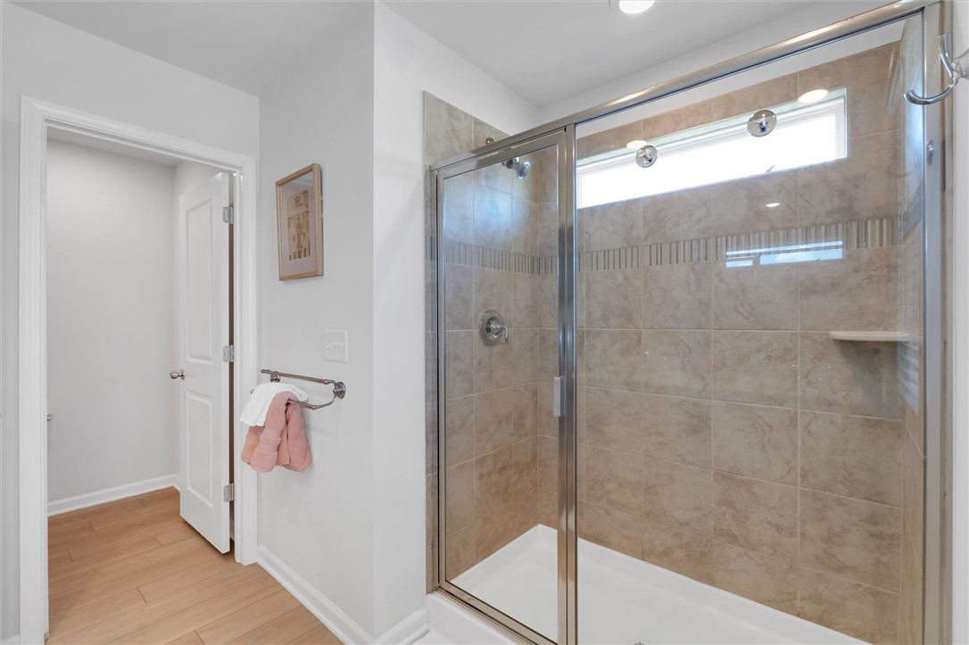 453 Bee Cv Way Pendleton, SC 29670 - Photo 16 of 25 A well-lit bathroom features a glass-enclosed shower, a private water closet, and LVP flooring.