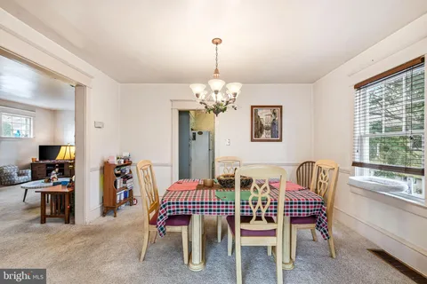 a dining room with furniture a chandelier and window