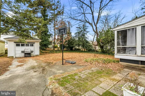 a tall yellow house with trees in the background