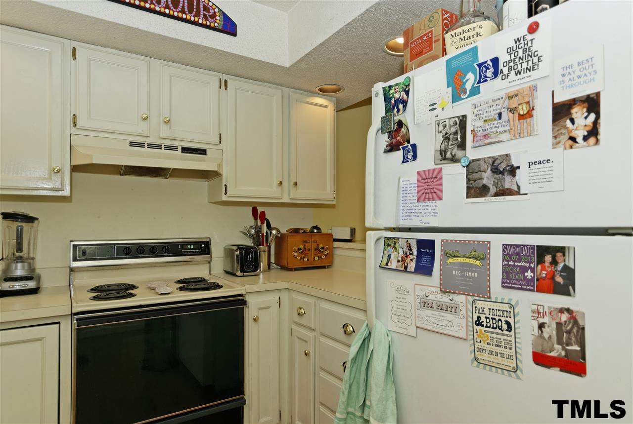 1454 Barton Pl Drive Raleigh, NC 27608 - Photo 11 of 25 a kitchen with stainless steel appliances granite countertop a stove and white cabinets