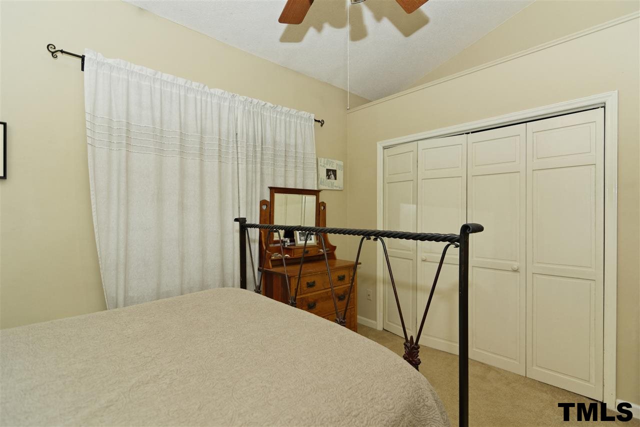 1454 Barton Pl Drive Raleigh, NC 27608 - Photo 15 of 25 a bedroom with a bed and a chandelier