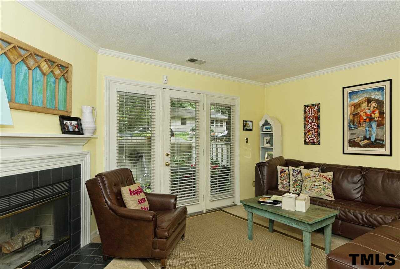 1454 Barton Pl Drive Raleigh, NC 27608 - Photo 4 of 25 a living room with furniture a flat screen tv and a fireplace