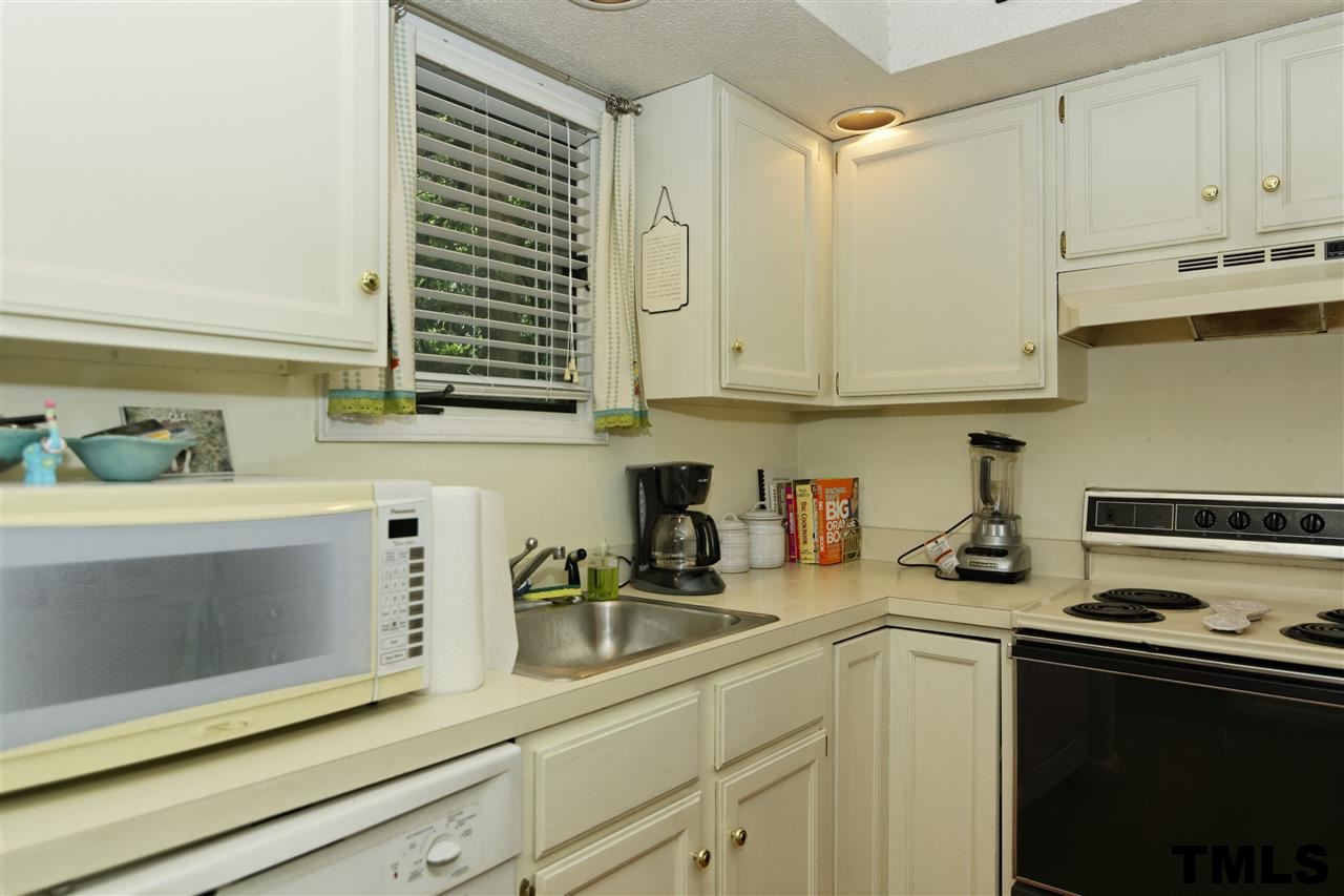 1454 Barton Pl Drive Raleigh, NC 27608 - Photo 9 of 25 a kitchen with stainless steel appliances granite countertop a sink a stove and cabinets