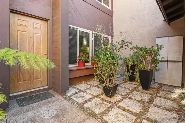 a view of a entryway door and potted plants