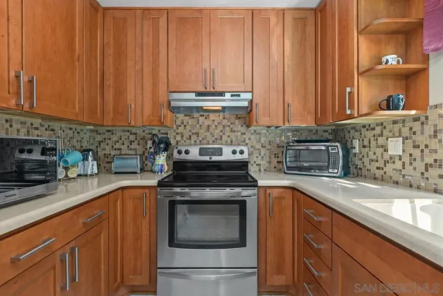 a kitchen with stainless steel appliances granite countertop wooden cabinets a sink and a stove
