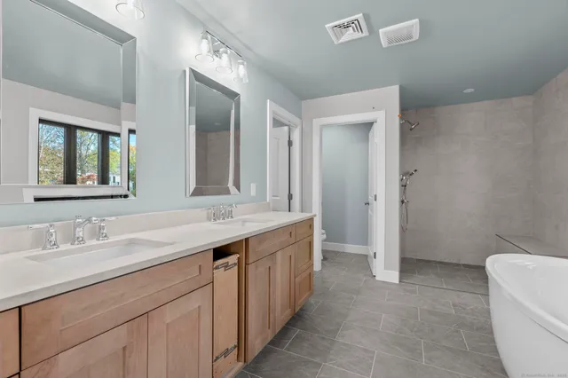 a view of an empty room with wooden floor and chandelier