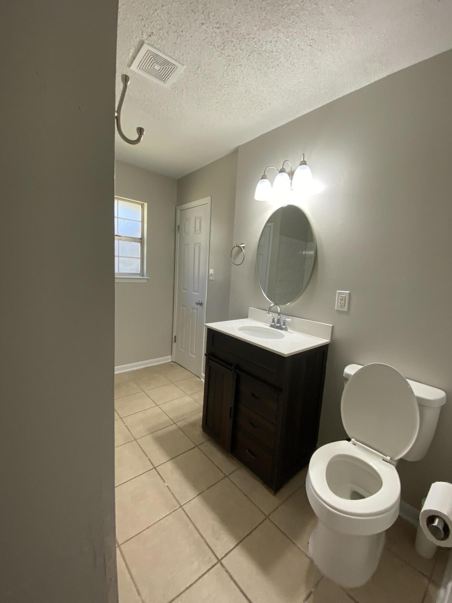 6173 Old Hickory Road Crestview, FL 32539 - Photo 11 of 22 a bathroom with a toilet sink and mirror