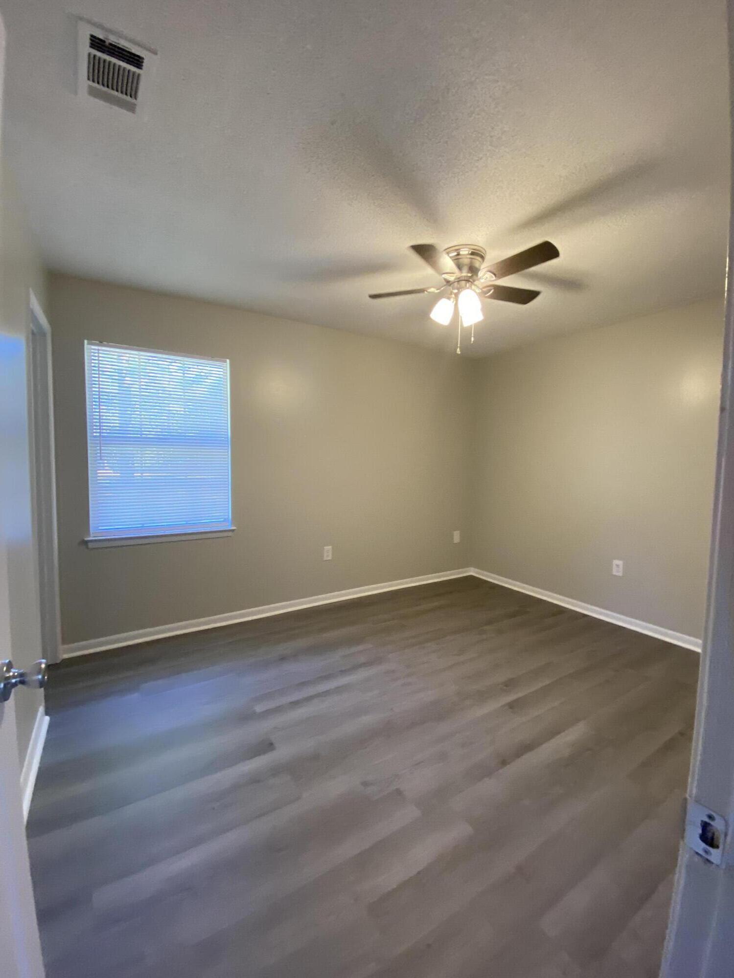6173 Old Hickory Road Crestview, FL 32539 - Photo 15 of 22 an empty room with wooden floor fan and windows