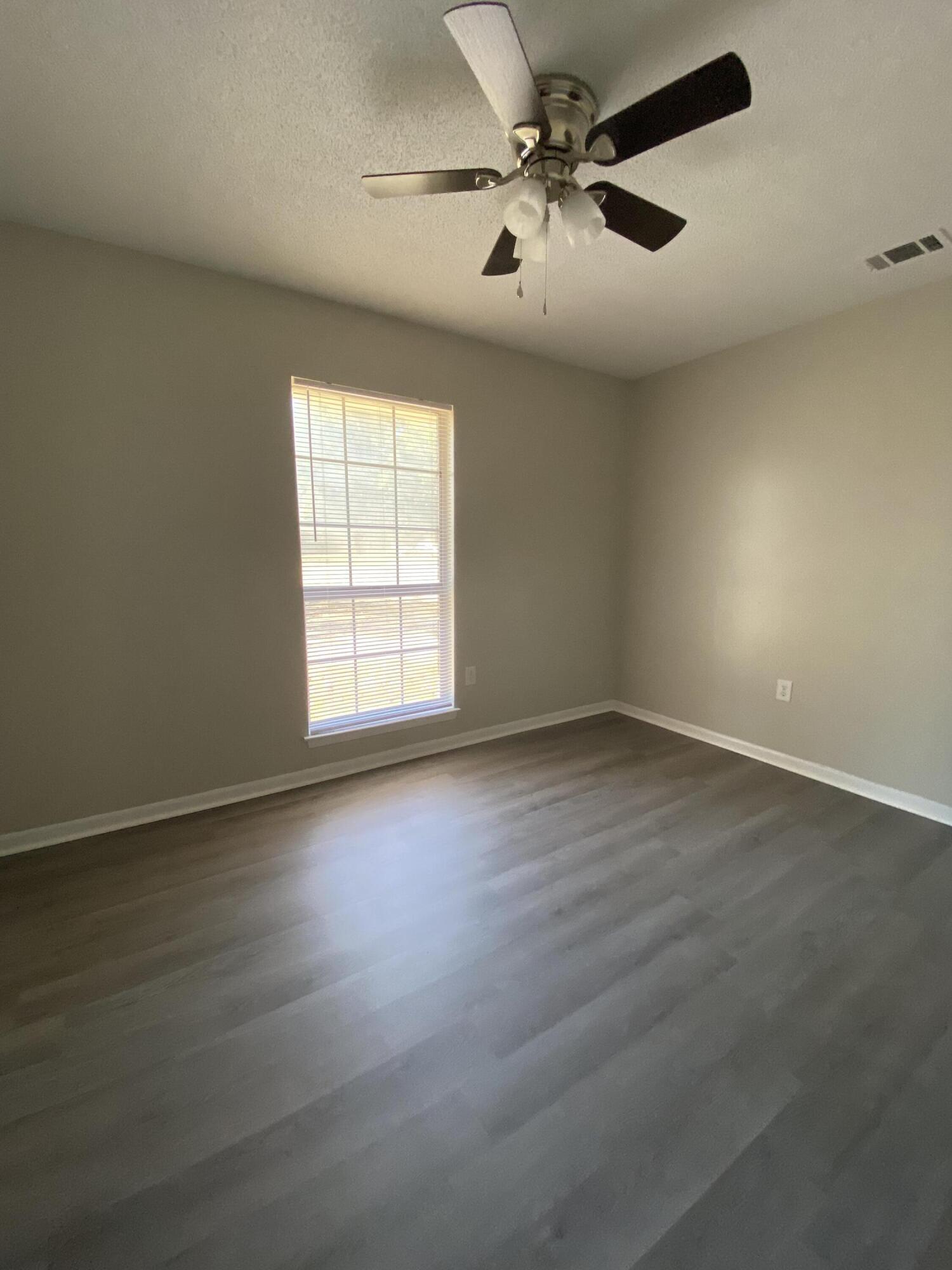 6173 Old Hickory Road Crestview, FL 32539 - Photo 18 of 22 an empty room with wooden floor fan and windows