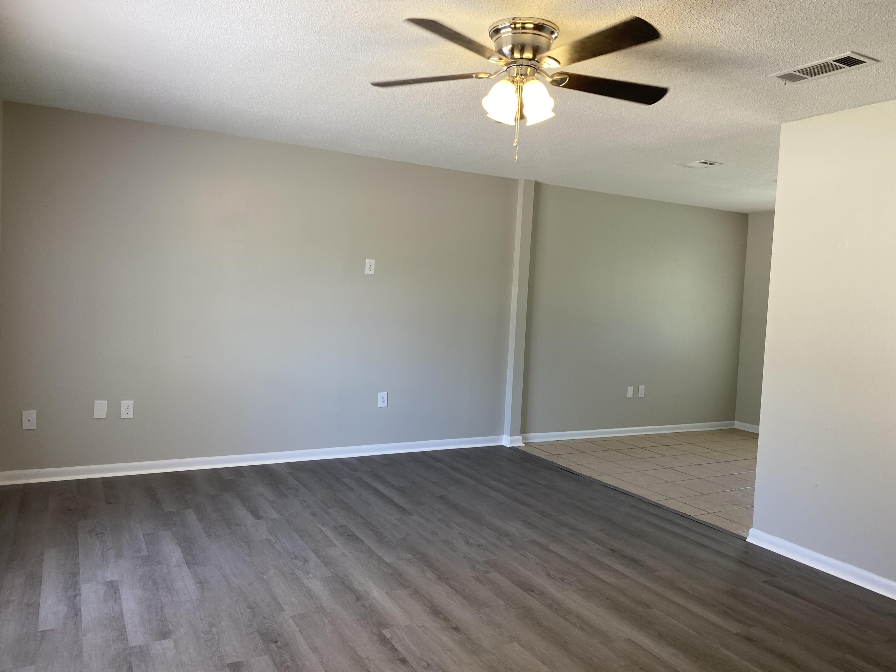6173 Old Hickory Road Crestview, FL 32539 - Photo 3 of 22 an empty room with wooden floor a ceiling fan and closet