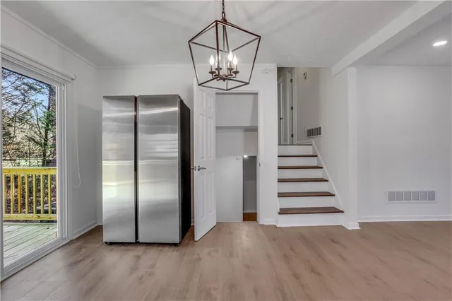 a view of a livingroom with wooden floor and stairs