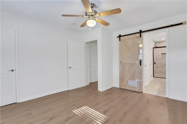a view of empty room with wooden floor and fan