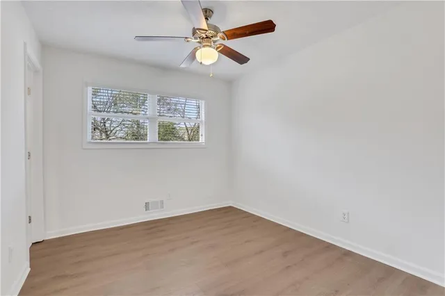 an empty room with a window and a fan