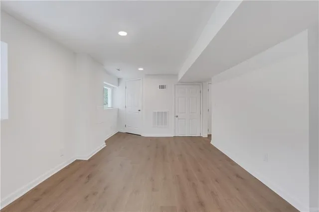 a view of an empty room with wooden floor