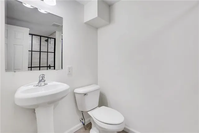 a bathroom with a toilet sink and mirror