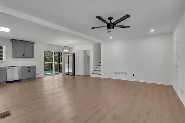 a view of a livingroom with a ceiling fan a kitchen space with a sink