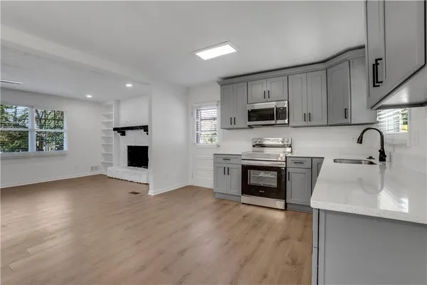 a kitchen with granite countertop a stove a sink and a microwave