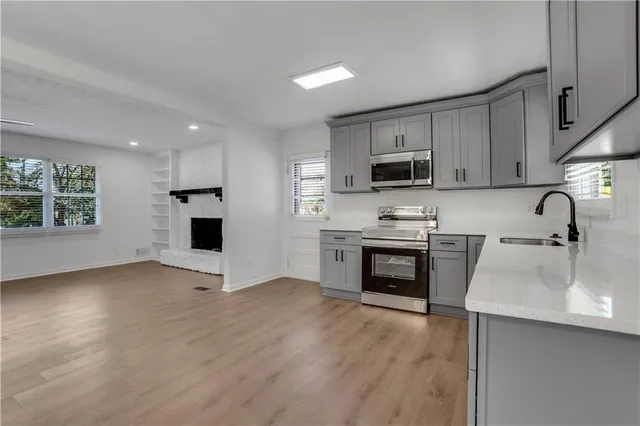 a kitchen with granite countertop a stove a sink and a microwave