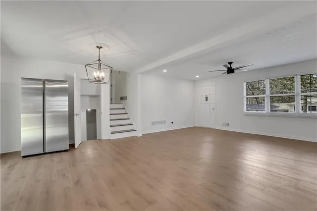 a view of empty room with wooden floor and window