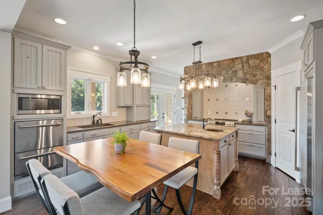 a large kitchen with kitchen island a stove a sink a dining table and chairs