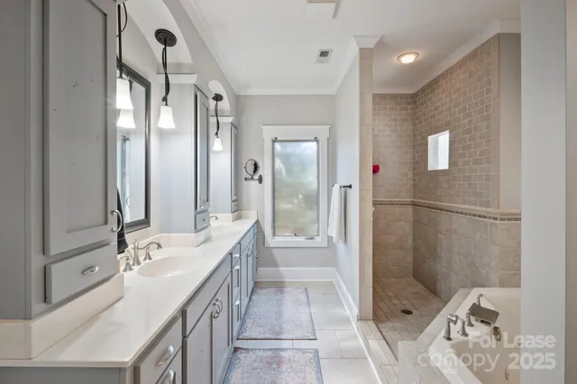 a bathroom with a double vanity sink a toilet a mirror and shower