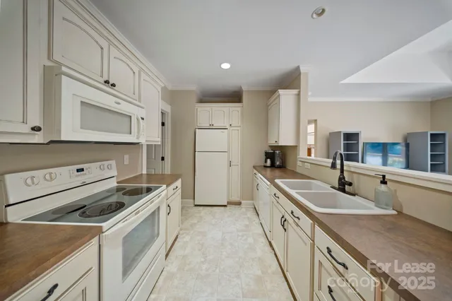 a kitchen with white cabinets sink and stove