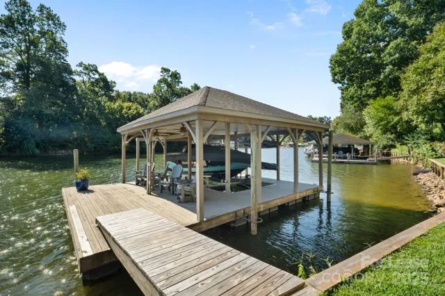 a view of a house with pool deck and a backyard