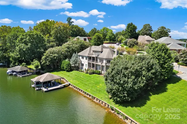 an aerial view of a house with a garden and lake view