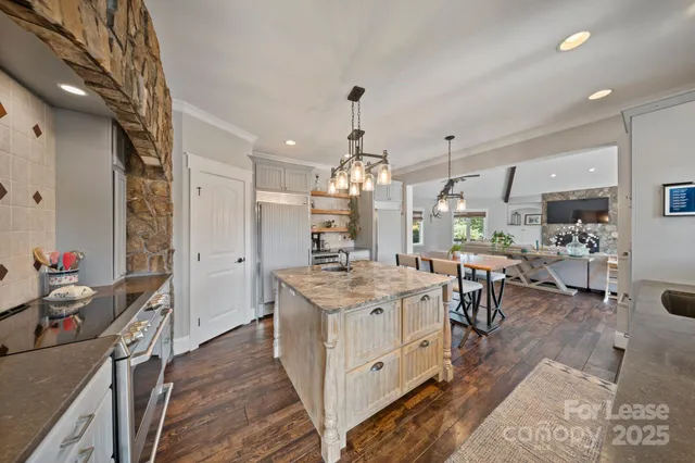 a open kitchen with stainless steel appliances granite countertop a stove oven and a refrigerator
